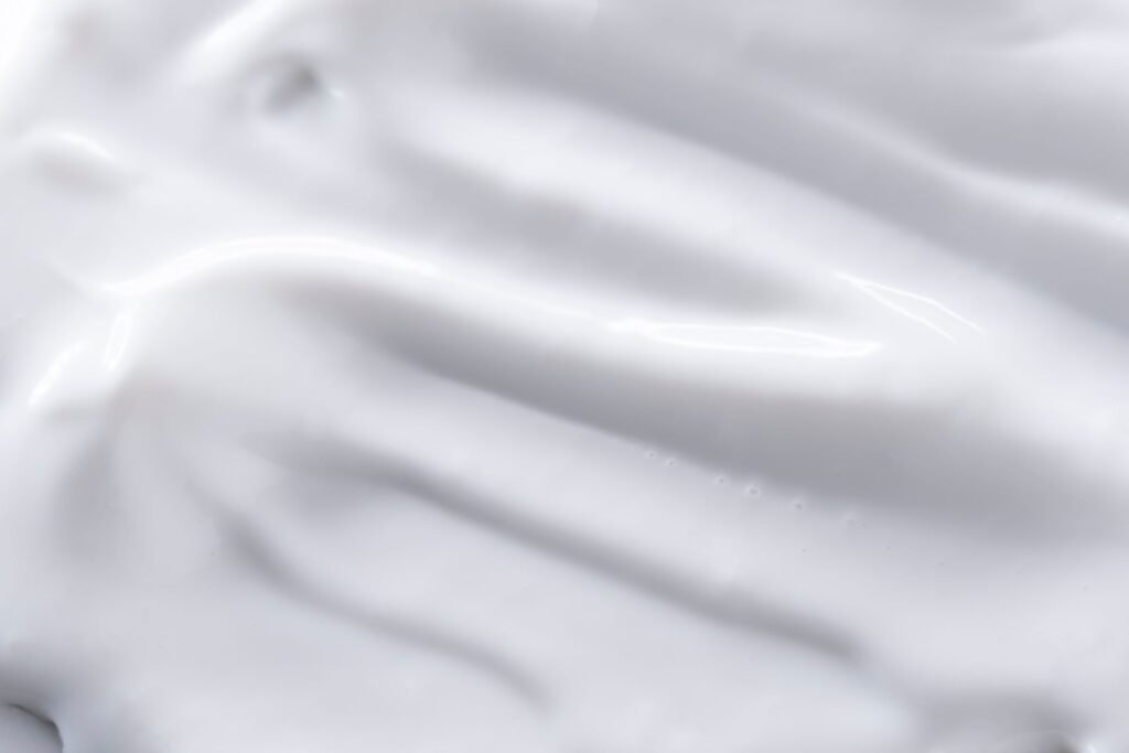 Close-up of a smooth white cream texture in soft natural light
