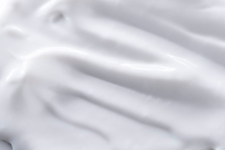 Close-up of a smooth white cream texture in soft natural light